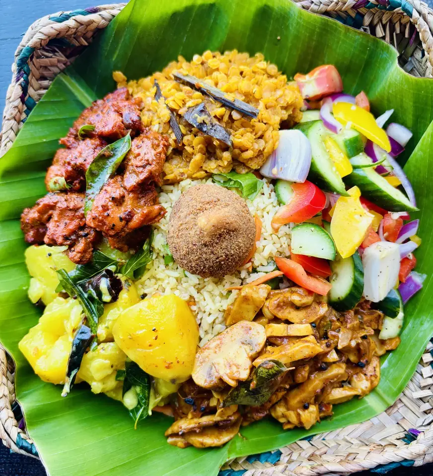 Rice and colourful curries served on a banana leaf